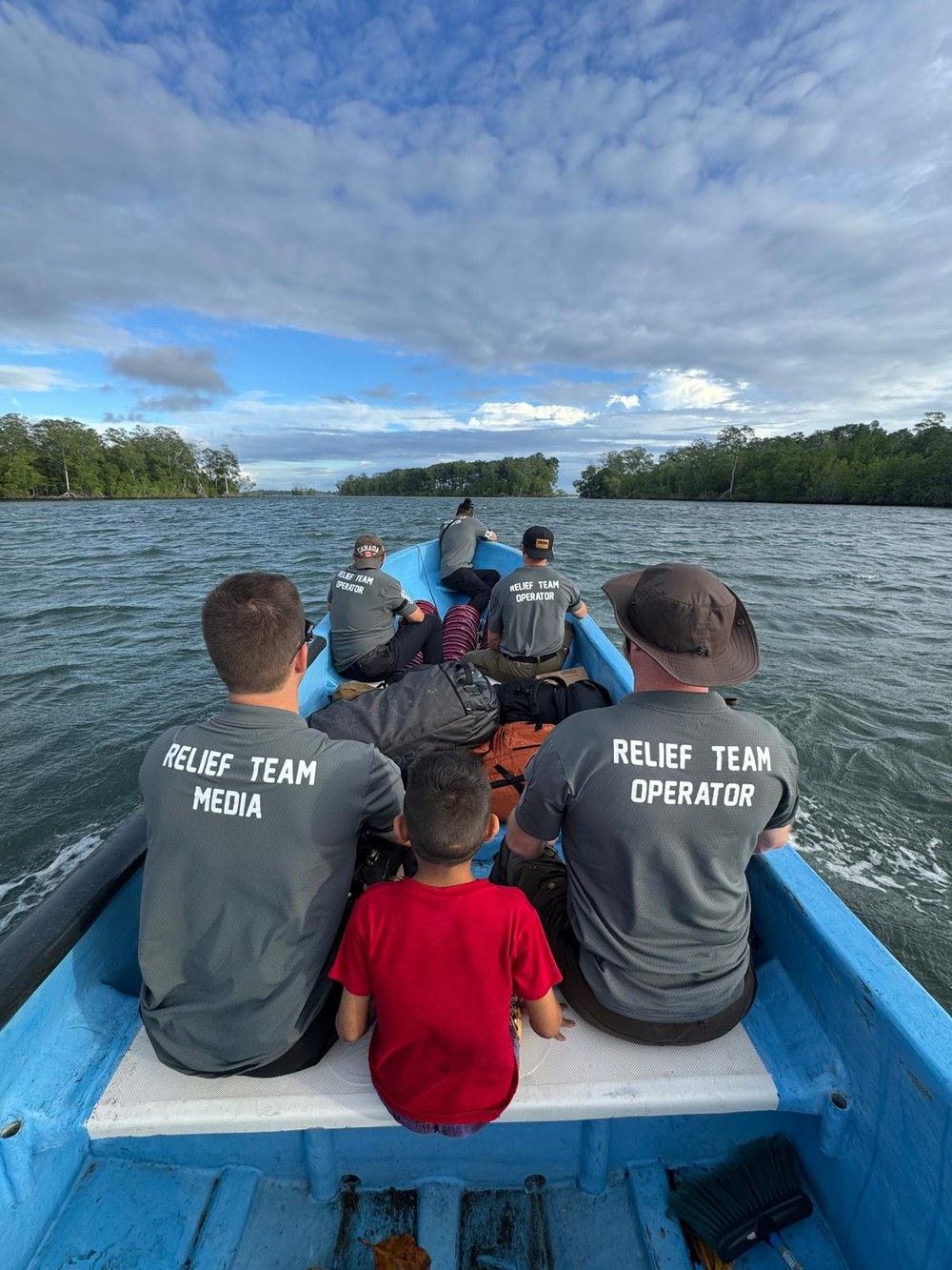 Des membres de l’équipe de V4LF dans une barque sur un cours d’eau, avec un enfant
